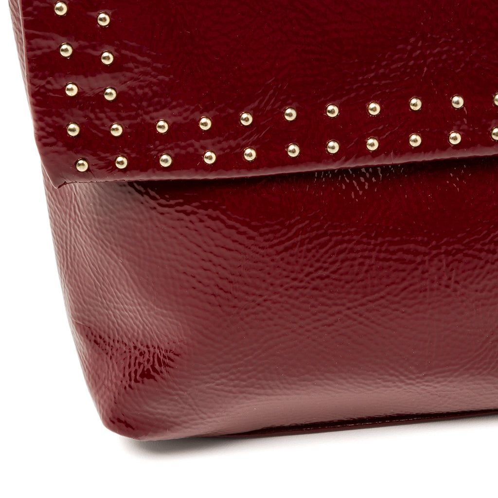 Borsa a tracolla bordeaux effetto lucido da donna con borchiette Lora Ferres