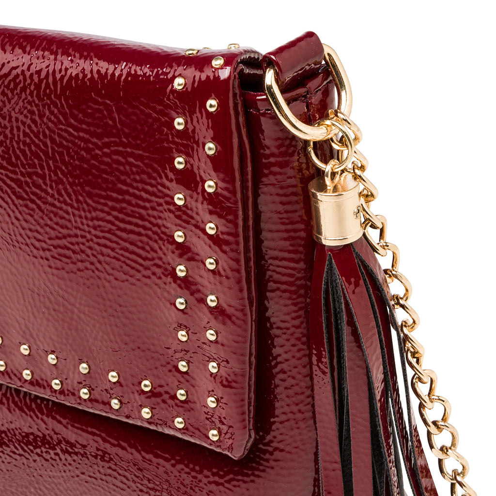Borsa a tracolla bordeaux effetto lucido da donna con borchiette Lora Ferres